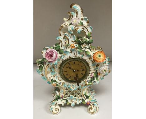 A 19th Century Continental Rococo style pottery cased mantel clock decorated with bird's nest and eggs, scrolling foliage and