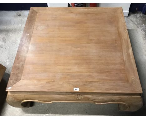 A pair of Andrew Martin teak coffee tables in the 19th Century Chinese style, the plain tops above shaped frieze on scroll le
