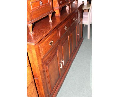 Reproduction oak sideboard, with four frieze drawers above four panelled cupboard doors, on a plinth base, 208cm wide