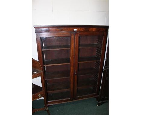 Mahogany glazed bookcase, with a cornice above two glazed doors enclosing shelves raised on bracket feet, 103cm wide