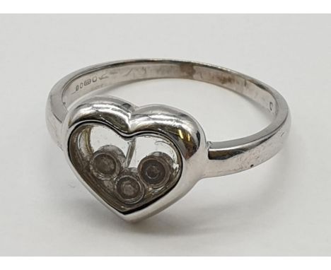 9ct white gold heart ring with 3 small moving diamonds to centre. Small crack to back. Size J. Weight 2.71 grams. 