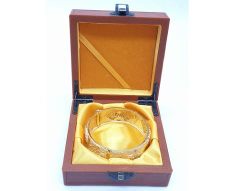 An Indian-Bollywood style gold filled bangle with laser pierced design.  In a presentation box. Internal diameter: 6.4cm 