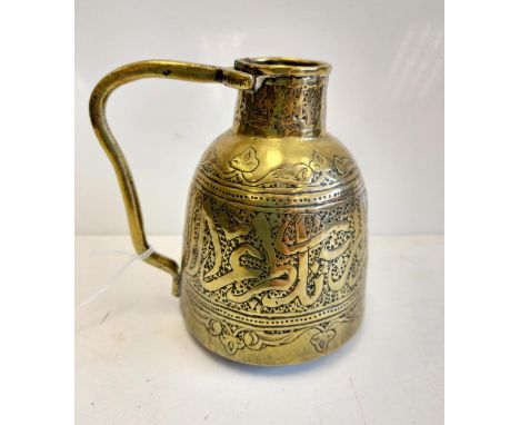 An antique Islamic brass jug with Arabic calligraphy. 12cm high. 