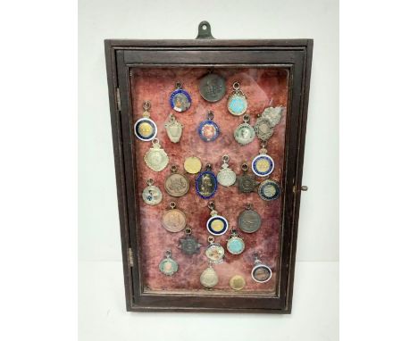 A selection of 28 vintage and antique athletic medals from a wide array of associations. Well presented in a wood framed glas