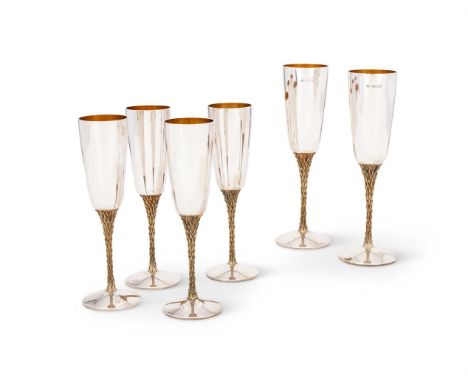 A SET OF SIX SILVER CHAMPAGNE FLUTESSTUART DEVLIN, LONDON 1978On gilded foliate stems and on circular spreading feet21.5cm (8