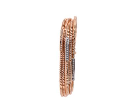 A DIAMOND SPRUNG BANGLEThe five sprung bangles to a barrel clip clasp, four of the bangles with two colour brilliant cut diam