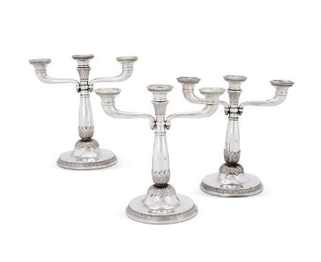 A SET OF THREE FRENCH ELECTRO-PLATED THREE LIGHT CANDELABRACHRISTOFLE, 1935 - 1983 MARKWith circular sconces, twin scroll bra