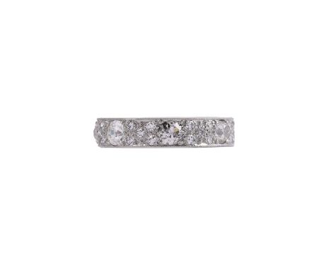 A PLATINUM AND DIAMOND ETERNITY RING LONDON 1982The platinum band set with old mine cut diamonds with eight cut diamonds betw