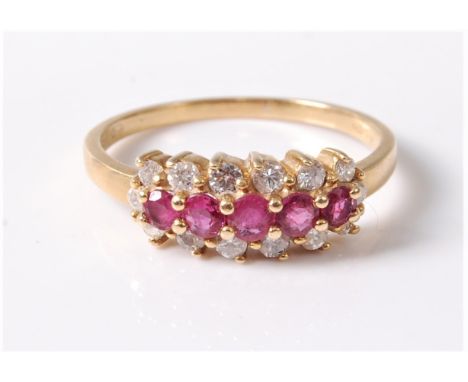 An 18ct ruby and diamond ring, the central row of five slightly graduated round rubies surrounded by small round diamonds, to