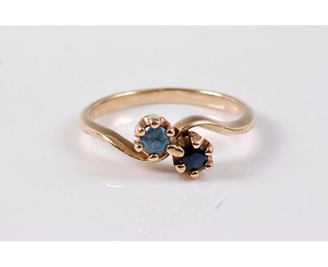 A two stone sapphire crossover ring, the dark and light blue sapphire ring, each approx. 4.2mm diameter, both claw mounted to