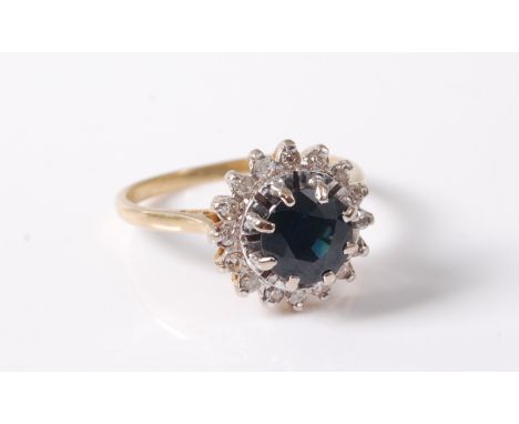 An 18ct sapphire and diamond cluster ring, the round deep blue sapphire surround by small round diamonds, all claw mounted in