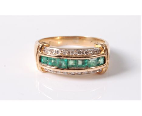 An emerald and diamond ring, the central channel of calibre cut emeralds set to either side with small round diamonds, with r