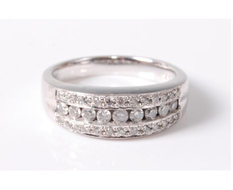 An 18ct diamond ring, the central row of round brilliant cut diamonds set to either side with a channel of small round diamon