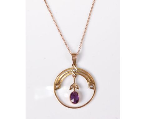 An Edwardian style amethyst and seed pearl pendant, the oval faceted amethyst suspended within a ring of yellow metal 2cm dia