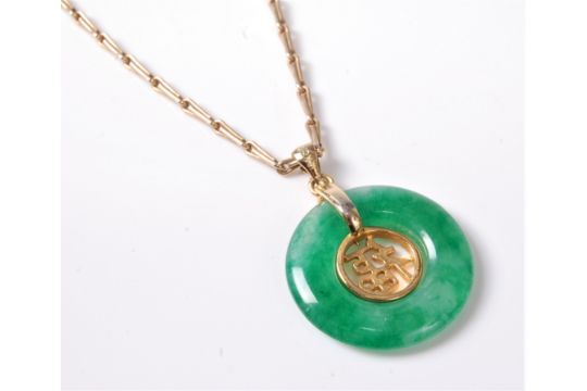 A Chinese jade pendant and 9ct chain, the round jade pendant with