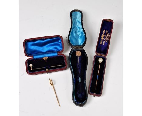 Four stick pins: a 5.7mm off-round 'pearl' with adaptable screw fitting, plain pin and stud back stamped '18ct'; a horseshoe 