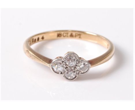 An early 20th century 18ct diamond ring, the four old round brilliant cut diamonds, all set in white metal to a plain band of