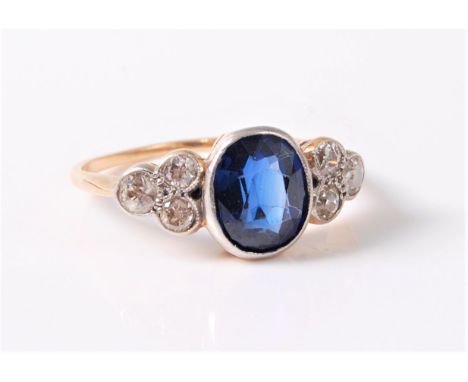 An 18ct synthetic sapphire and diamond ring, the oval synthetic sapphire, approx. 8.3 x 7mm, in a millegrain mount, set to ei