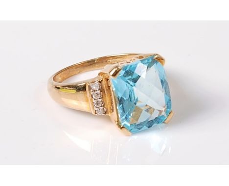 A 9ct aquamarine and diamond ring, the fancy cut aquamarine, in four corner claws, set with four small round diamonds to each