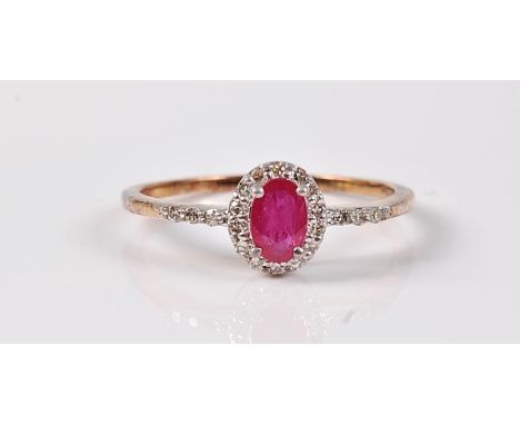 A treated ruby and diamond ring, the oval treated ruby, surrounded by small round diamonds, overall approx. 8.2mm long, shoul