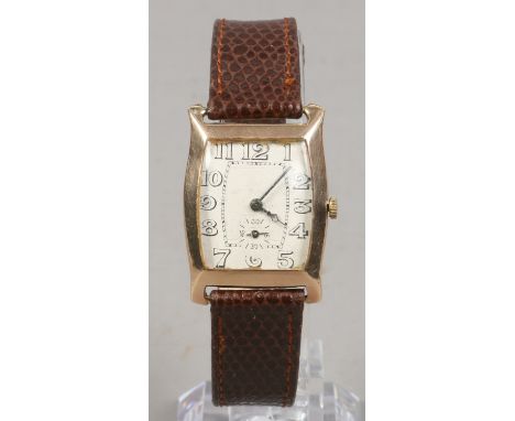 A gents 9ct gold cased manual watch on brown leather strap.