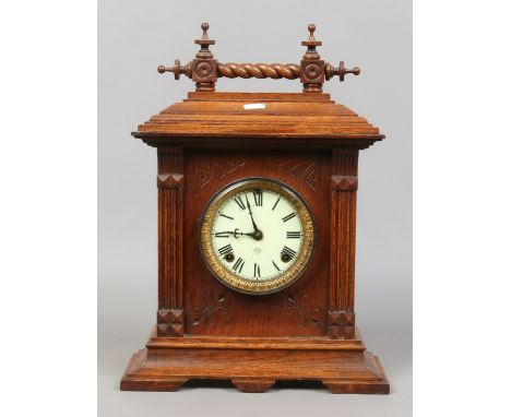 An American oak cased eight day mantle clock chiming on a coiled gong with brass and enamel dial complete with pendulum and k