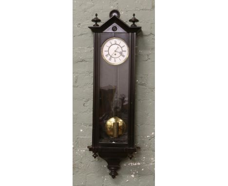 A 19th century ebonized cased Vienna wall clock with white enamel and brass dial Roman numeral markers complete with brass we