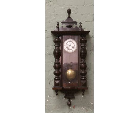 A late 19th early 20th century walnut cased 8 day Vienna clock, chiming on a coiled gong with white enamel dial and pointed b