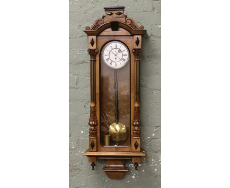 A 19th century walnut 8 day cased Vienna wall clock with carved columns white and brass dial subsidiary second dial pendulum,