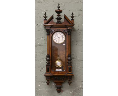 A burr walnut cased 19th century springer wall clock with white enamel dial, Roman numerals and carved column decoration.