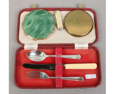 A cased silver christening set; knife, fork spoon, two powder compacts and a pocket knife.