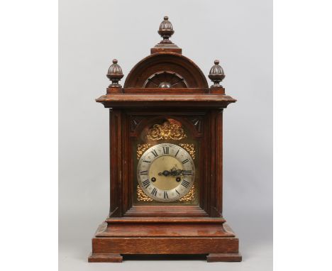An early 20th century oak cased 8 day mantel clock quarter chiming on two coiled gongs with key and pendulum.
