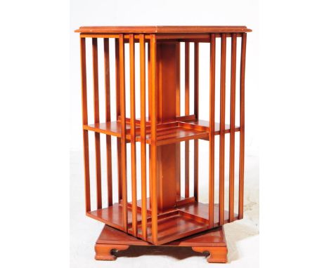 A vintage 20th century yew wood veneer Sheraton revival revolving bookcase. Of square form with inlaid decoration to top, sec