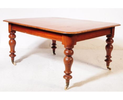 A late Victorian 19th century mahogany extending dining table. Curved rectangular form with chunky turned supports terminatin