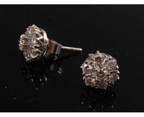 A pair of white metal diamond circular cluster ear studs, each featuring seven round brilliant cut diamonds in claw settings,