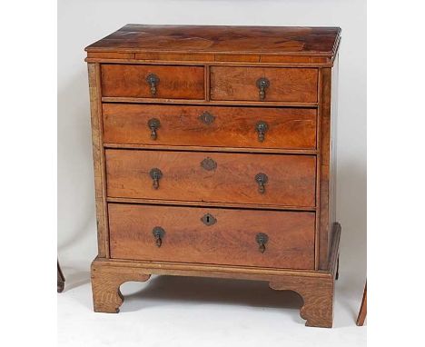 An antique walnut and oyster veneered chest, of small proportions, having pine sides and carcass, two short and three long gr