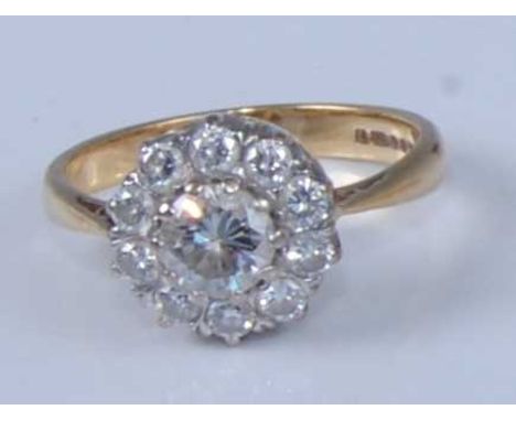 An 18ct yellow and white gold diamond circular cluster ring, featuring a large centre round brilliant cut diamond within a bo