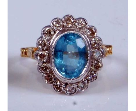 A yellow and white metal, aquamarine and diamond oval cluster ring, featuring a centre oval aquamarine within a border of six
