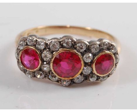 An Edwardian yellow and white metal synthetic ruby and old European cut diamond triple cluster ring, featuring three graduate