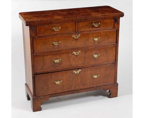 *A George II figured walnut bachelors chest, having a fold-over top above two short and three long graduated and feather band