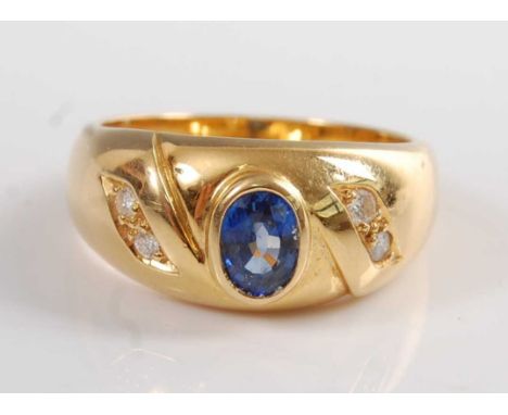 An 18ct yellow gold, sapphire and diamond 'Gypsy' style ring, comprising an oval sapphire in a bezel setting, with two round 