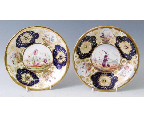 A pair of circa 1820 English porcelain footed bowls, each enamel decorated with floral reserves within cobalt blue and gilt b