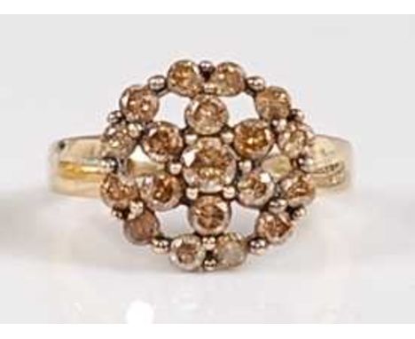 A 9ct yellow gold diamond circular cluster ring, featuring nineteen fancy light brown diamonds in claw settings, diamond dime