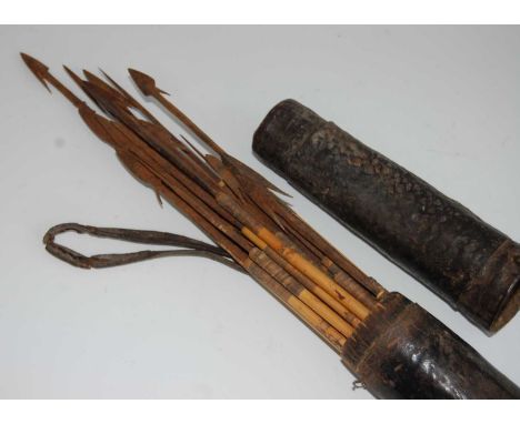 A collection of 19th century hunting arrows, each having a flattened iron spear point blade with barbed shaft, mounted on fur