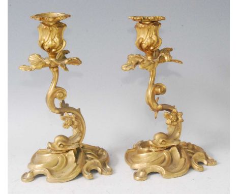 A pair of Rococo Revival gilt bronze Dolphinium candlesticks, each on swept bases and issuing twin flowers, early 20th centur