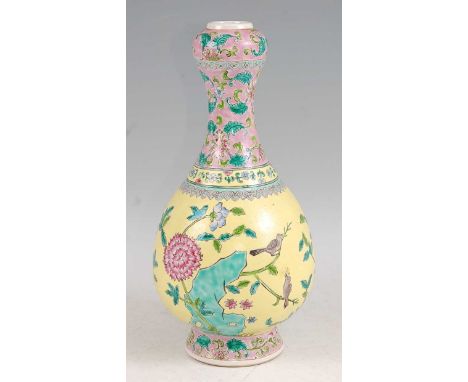 An early 20th century Chinese yellow and pink floral enamel decorated onion necked vase, having baluster body, raised on flar