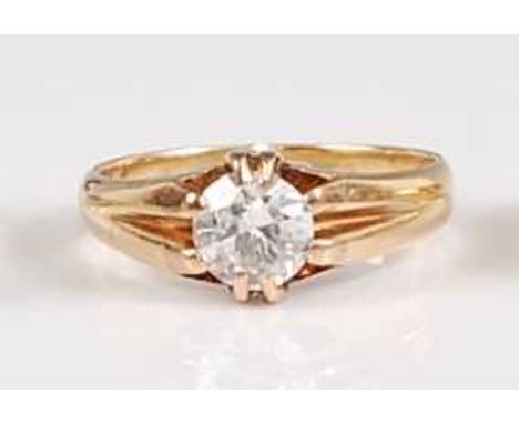 A yellow metal diamond solitaire ring, comprising a round brilliant cut diamond in an eight-claw heavy setting, with bifurcat