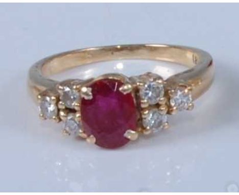 A yellow metal, ruby and diamond dress ring, comprising a centre oval faceted ruby with a trefoil of round brilliant cut diam
