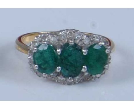 An 18ct yellow and white gold, emerald and diamond triple cluster ring, comprising three graduated oval emeralds in the centr