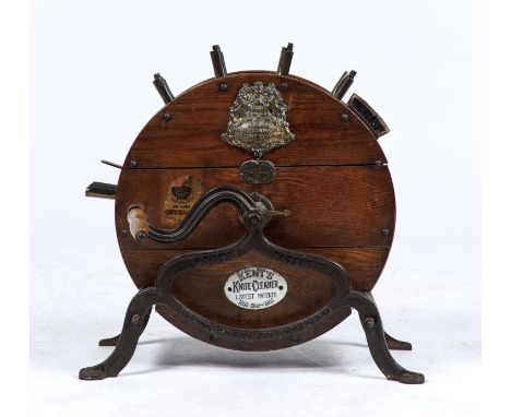 AN EDWARDIAN OAK CASED KENT'S KNIFE CLEANER, THE CYLINDRICAL CASE BEARING APPLIED TRADEMARK AND MAKER'S LABELS: KENT PATENTEE